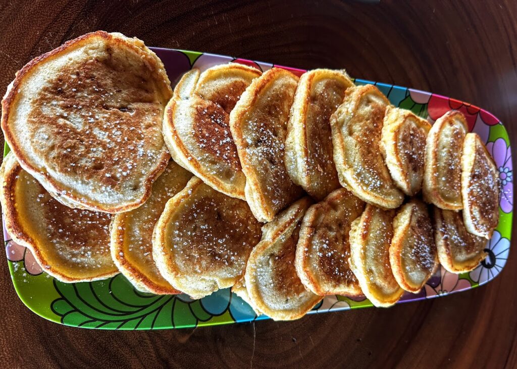 Homemade pancakes arranged from large to small on a colorful serving platter